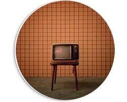 Forex Wandcirkel - Oude Televisie op Krukje voor Oranje Muur - 20x20cm Foto op Wandcirkel (met ophangsysteem)