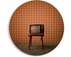 Forex Wandcirkel - Oude Televisie op Krukje voor Oranje Muur - 40x40cm Foto op Wandcirkel (met ophangsysteem)